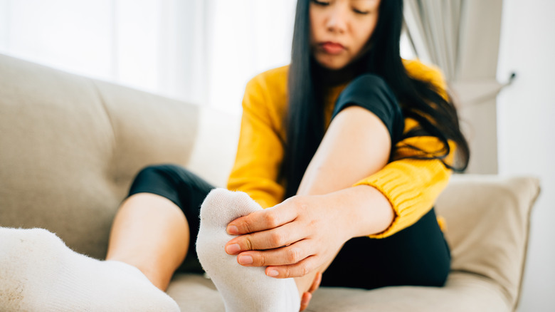 A woman holding her painful big toe