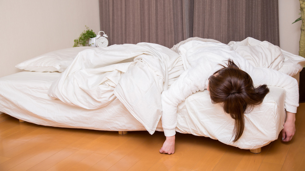 woman uncomfortable on bed