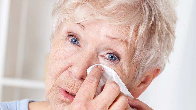 Woman dabbing eye with tissue