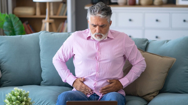 man on couch experiencing nausea