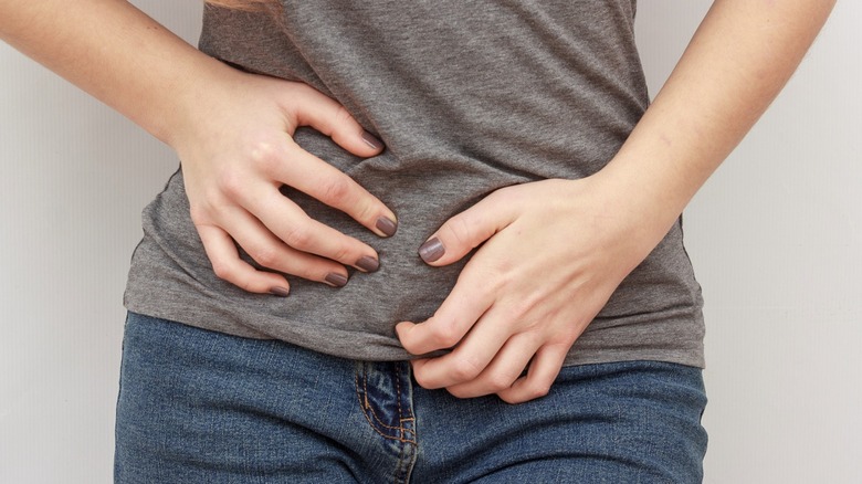 young woman with hands over stomach