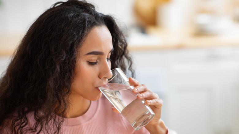 ﻿Woman drinking water from glass