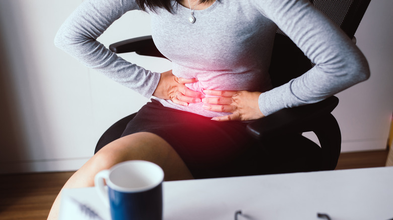 woman holding her abdomen in pain