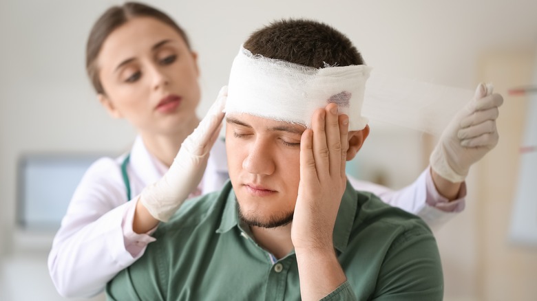 Doctor applying bandage to patient's head