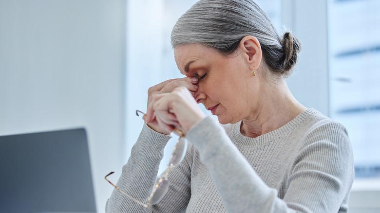 woman pinching her nose to relieve tension