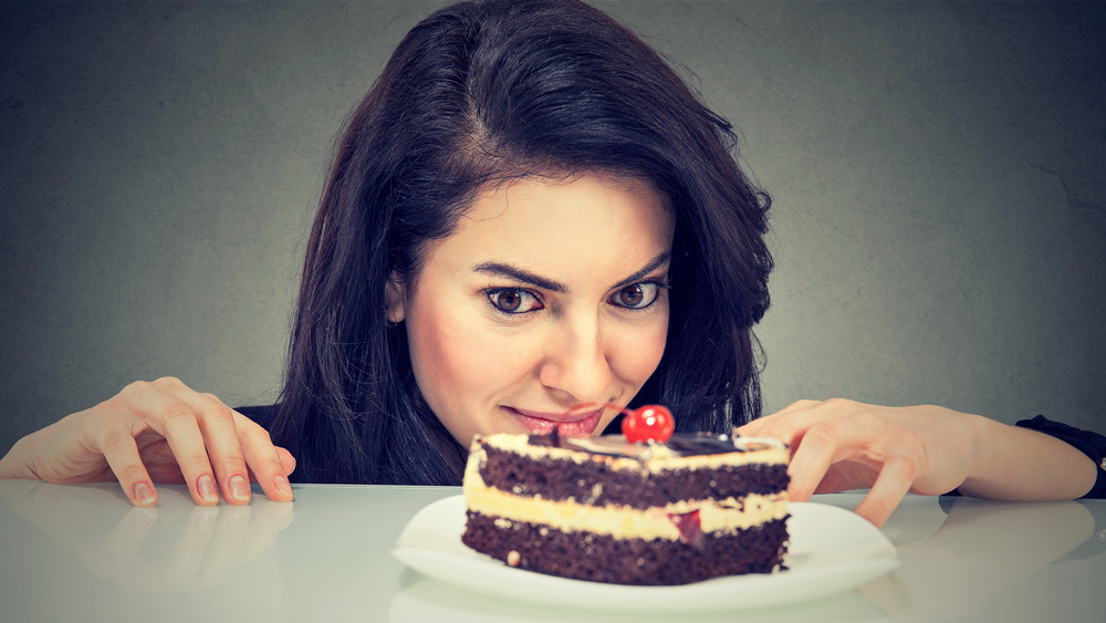 woman eying slice of cake