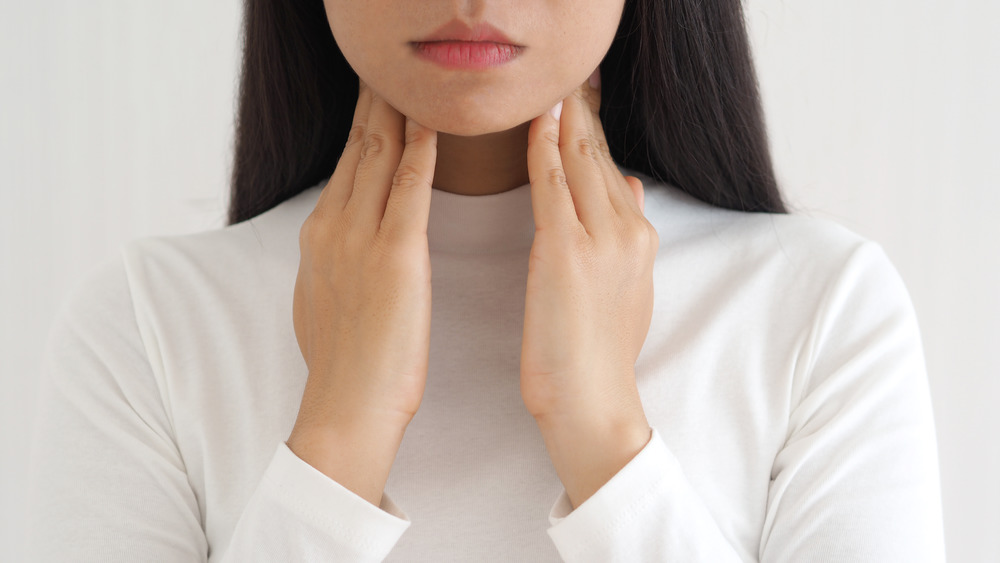 woman touching thyroid