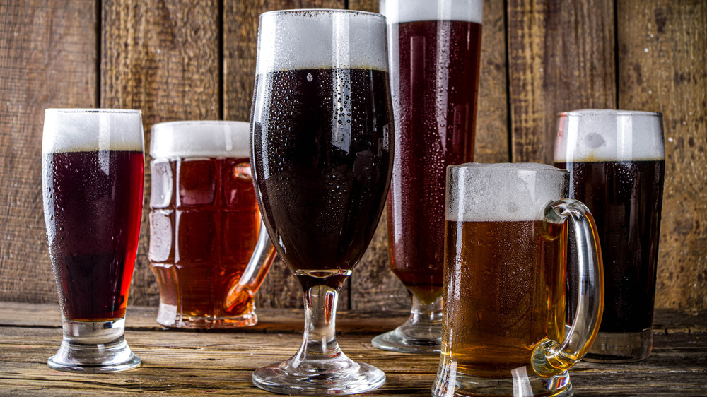 Several beers lined up on a wood bar