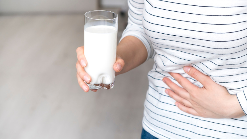 glass of milk, woman with stomach pain