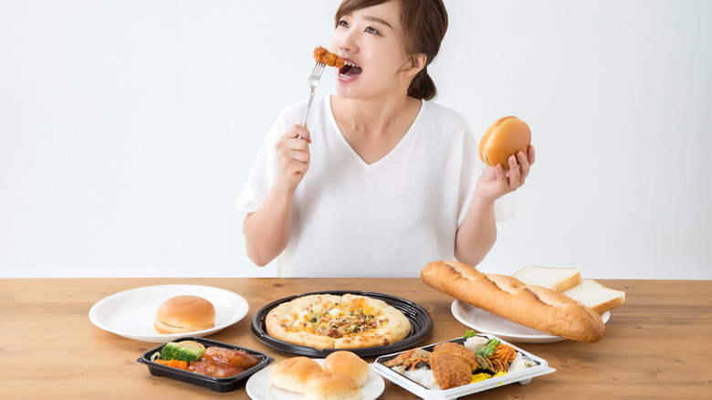 woman eating lots of fattening food 