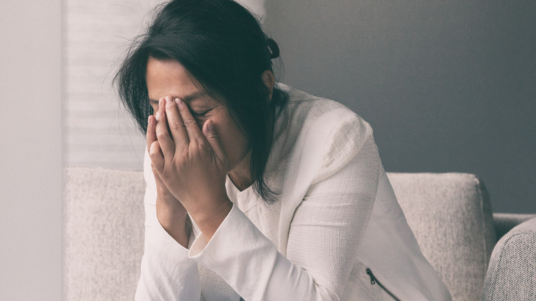 stressed woman with face in hands