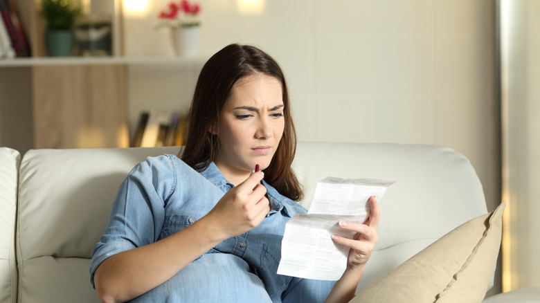 confused pregnant woman reading drug leaflet 