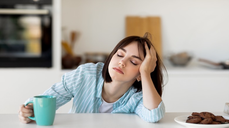 sleepy young woman drinking coffee