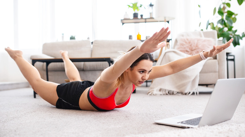 Woman performing superman exercise at home