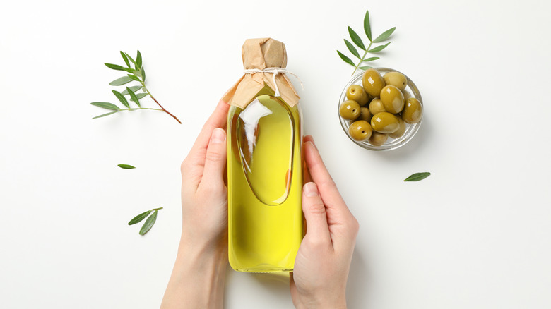 hands holding olive oil