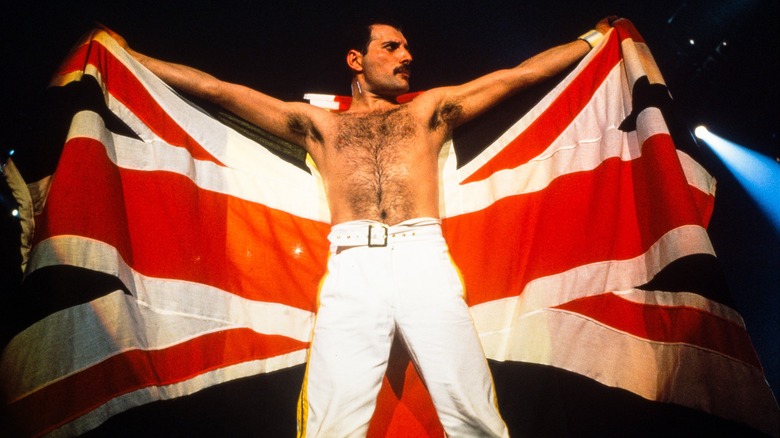 shirtless Freddie Mercury raising British flag