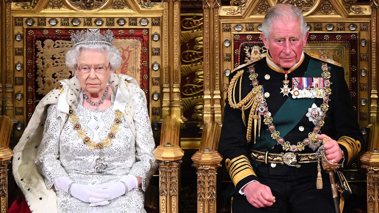 Queen Elizabeth and Prince Charles sitting in thrones 