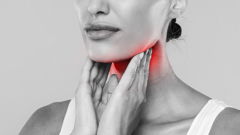 black and white photo of woman holding her throat