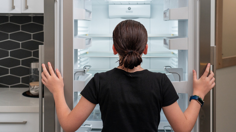 Woman standing in front of fridge 