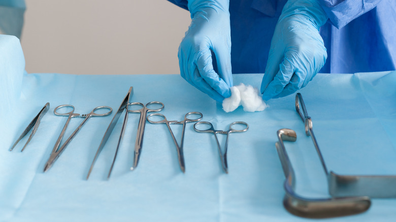 Gloved hands placing surgical equipment