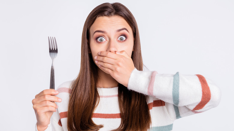 Shocked woman with fork