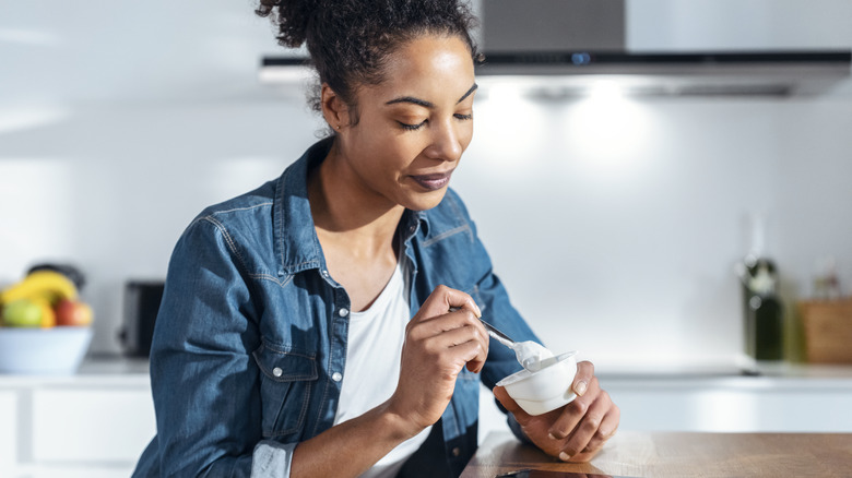 woman eating a cup of yogurt