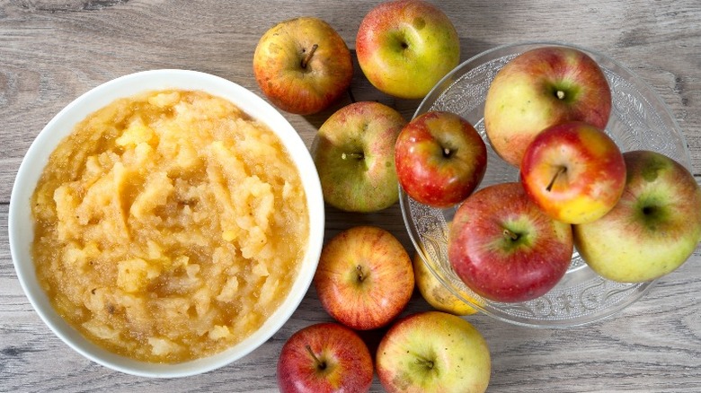 applesauce and apples on wooden surface