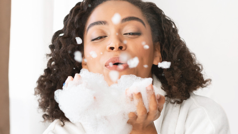 Woman blowing soap suds