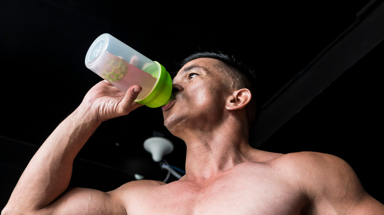 A man drinks a pre workout drink