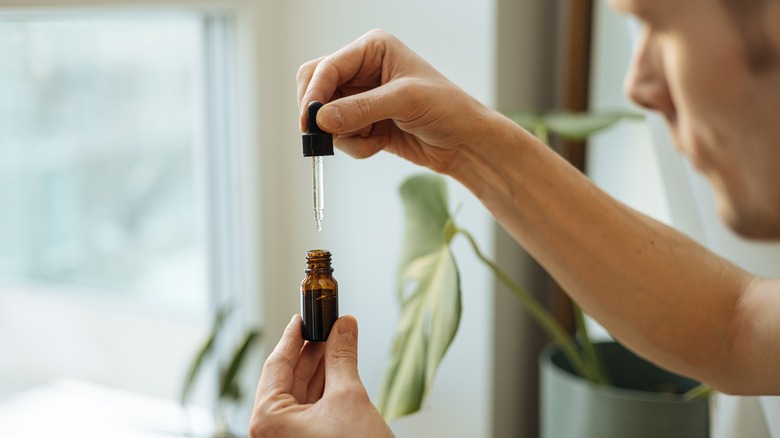 Man measuring oil from bottle