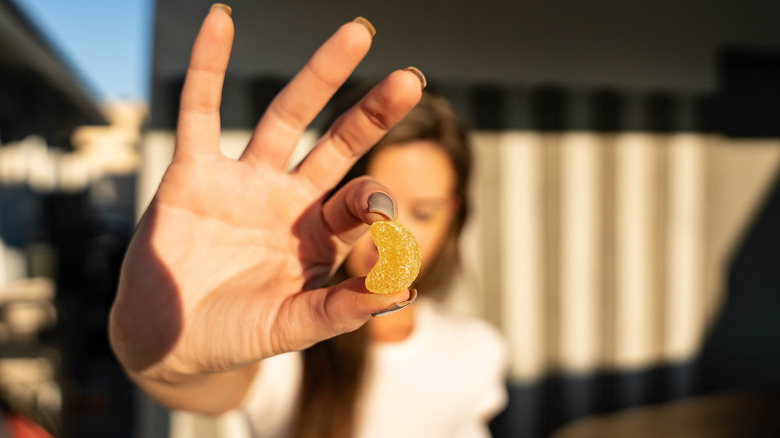 Woman holding CBD gummy