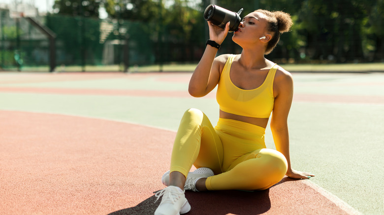 Fit woman drinking a protein shake with cornstarch