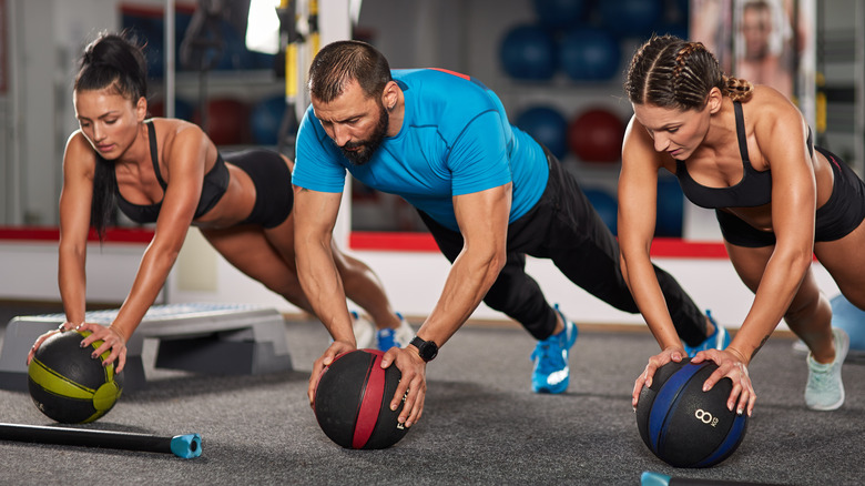 People doing medicine ball push-ups