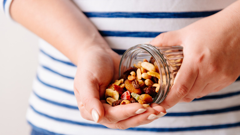 Woman holding a jar of nuts and dried fruits