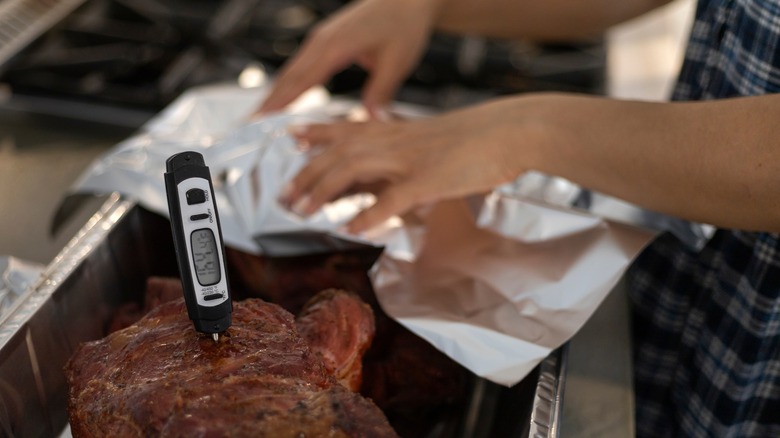 woman measuring meat temperature