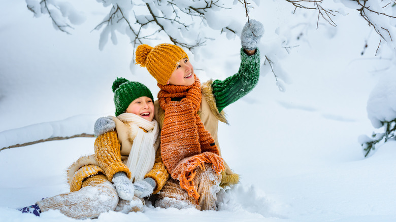 Two kids are playing in the snow