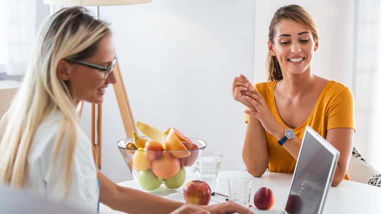 A dietician and a nutritionist speak with each other