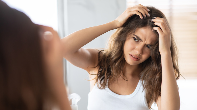 A woman looks at her hair