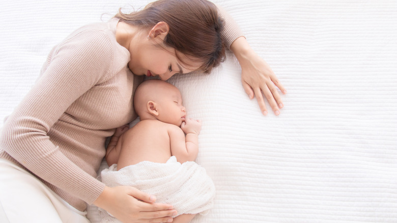 mother kissing her newborn 