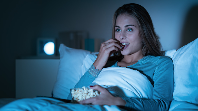 A woman snacks before bed