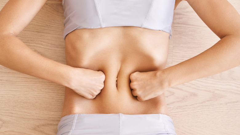 woman lying down pressing her stomach