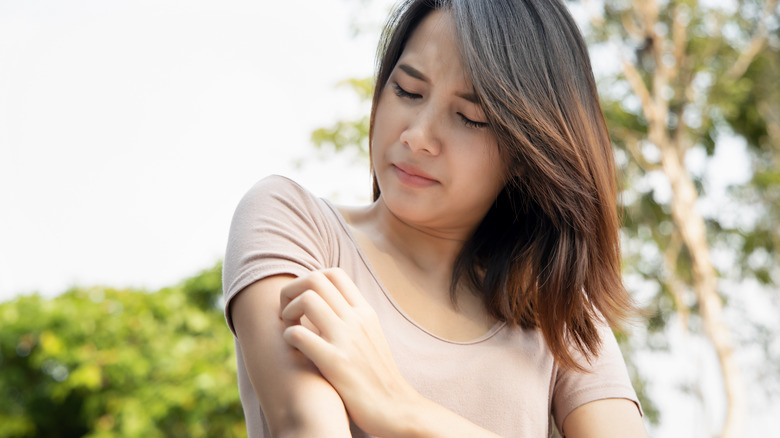 Woman itching her arm 