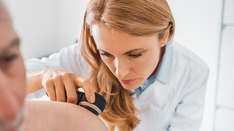 a dermatologist evaluates a patient's skin