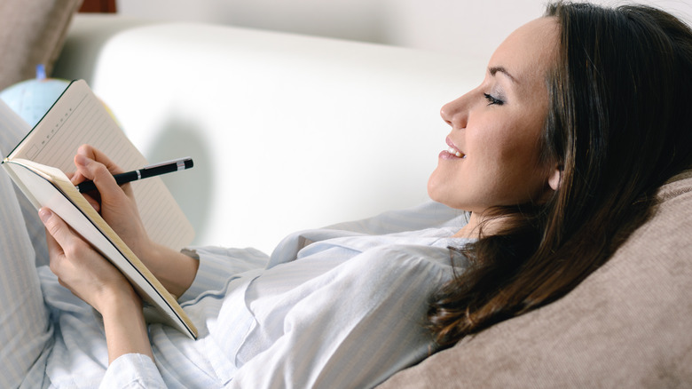 Woman in pajamas writing in journal