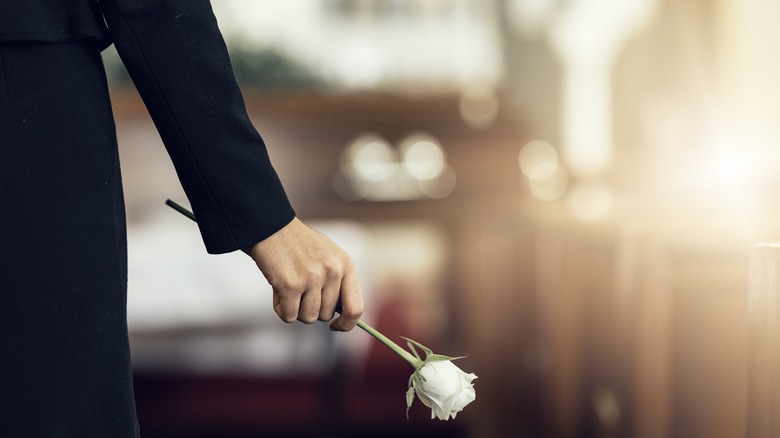 Woman holding white rose