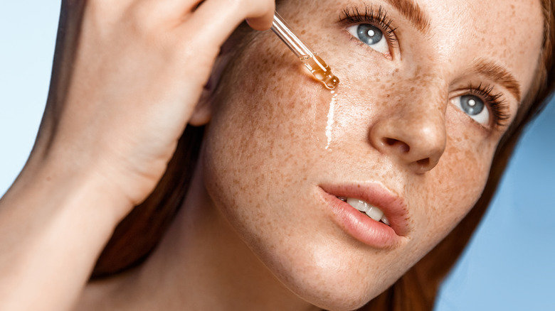 woman treating freckles with oil