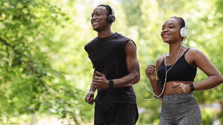 african man and woman jogging happily