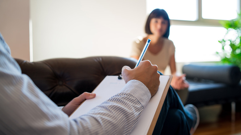 therapist taking notes with client