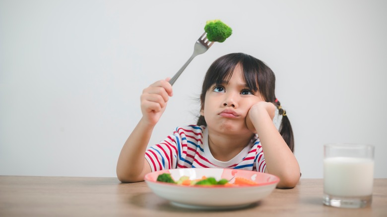 Young child eating vegetables for dinner