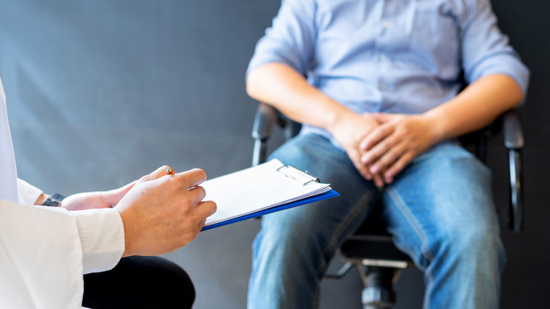 Man covering groin at doctor's office